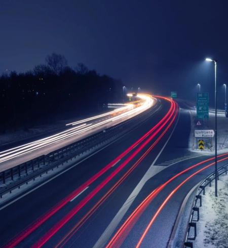 Een Sloveense snelweg bij nacht met lichtsporen van passerende voertuigen.