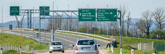 Green directional signs on the Slovenian A4 / E59 motorway pointing to Zagreb via Gruškovje border crossing and Graz / Maribor, with a 70 km/h speed limit sign