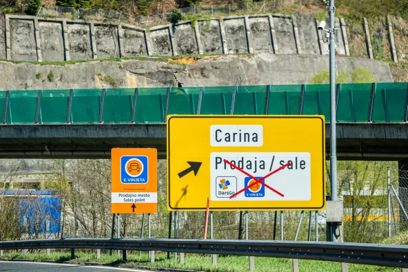 Slovenia E-Vinjeta sales point orange sign next to yellow Carina customs sign showing DarsGo available but E-Vinjeta crossed out indicating no vignette sales at this location, April 2026