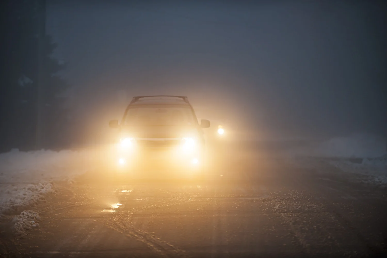 Словенский автомобиль во время движения в снегу и тумане с включенными фарами
