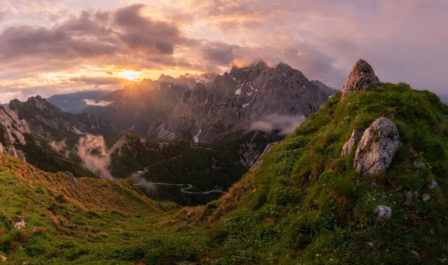 Horská krajina s klikatou silnicí v dálce - Julské Alpy